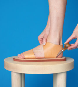 use an awl to mark slot placement on sandal footbed.
